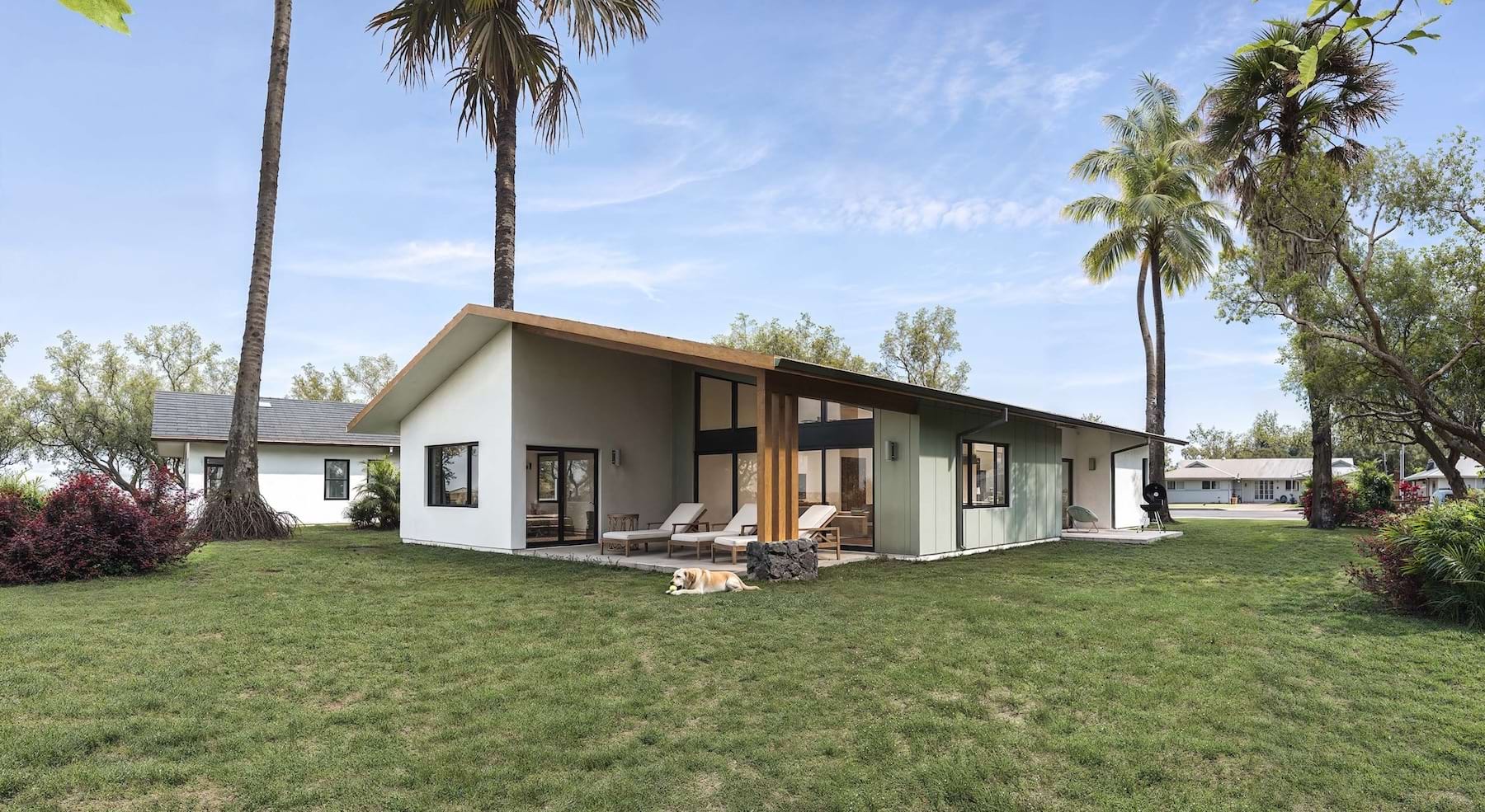 a home overlooking an ocean with a large lawn
