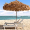 lounge chairs under an umbrella on a beach